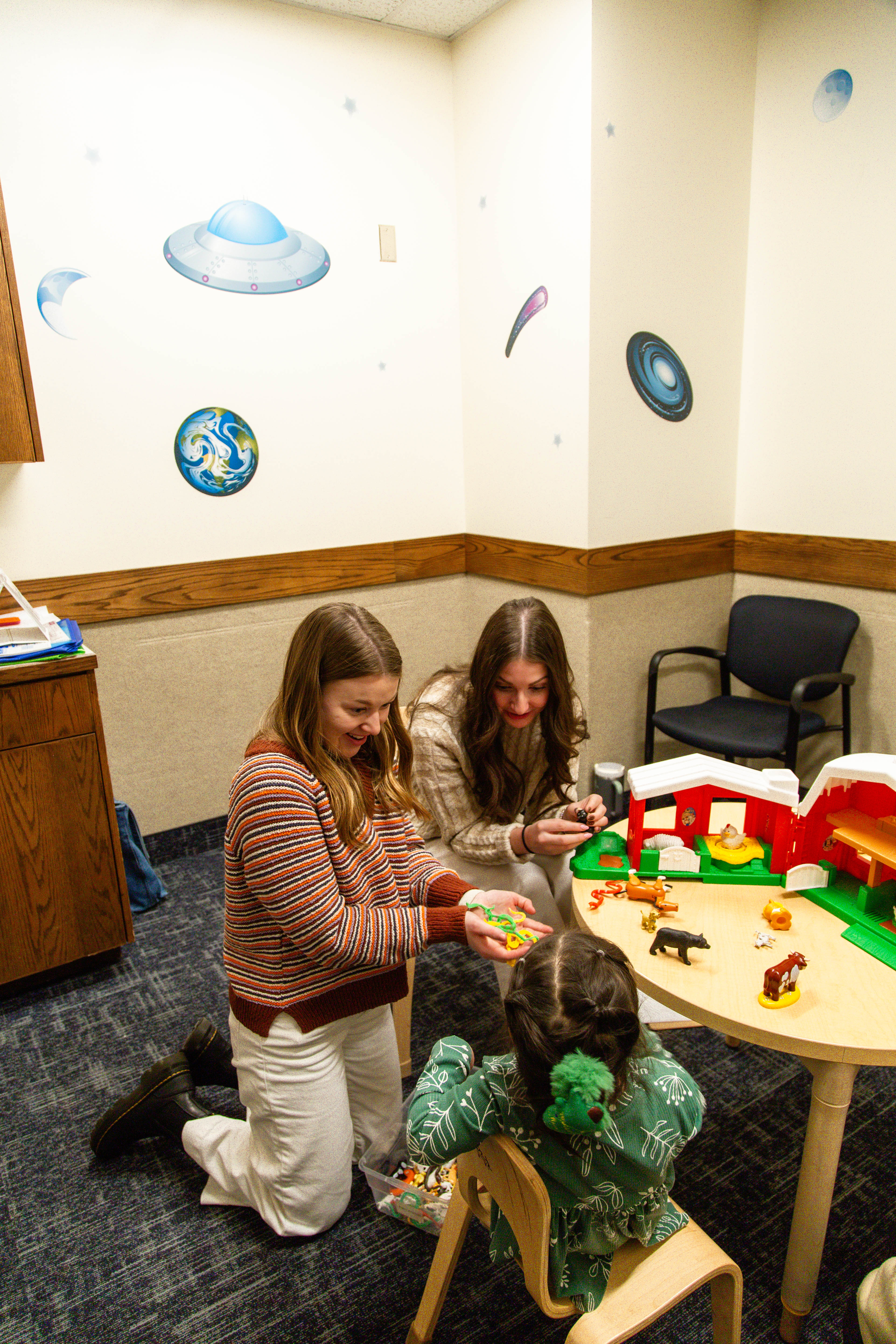 Full view students play with child with toy barn.jpg
