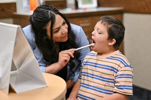a doctor checking a boy's tongue