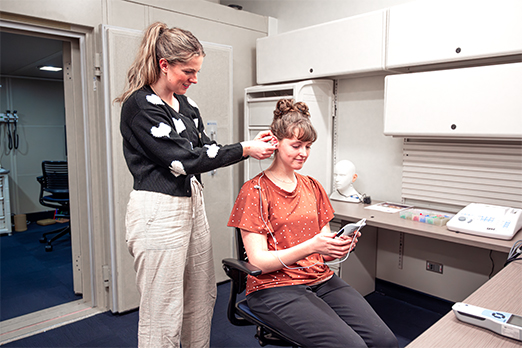 Two female students engage in audiology research