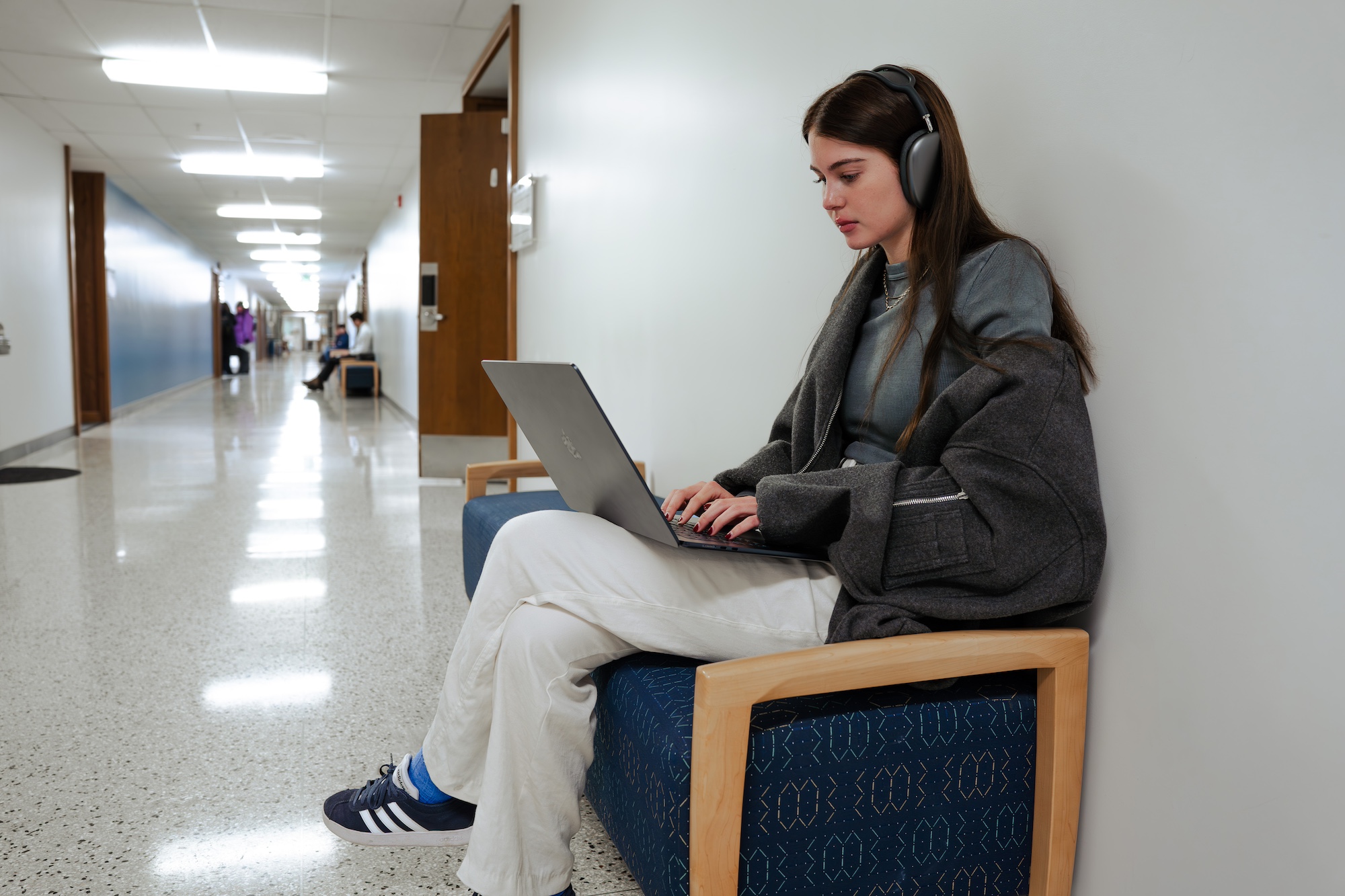 Student sitting on bench, working on laptop
