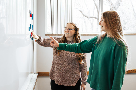 Two women at whiteboard