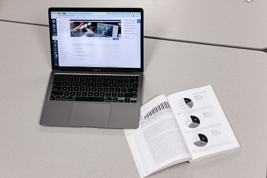 An open laptop by an open textbook