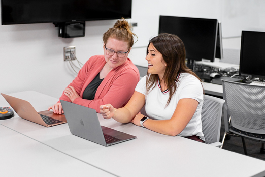 Two women talking over a laptop
