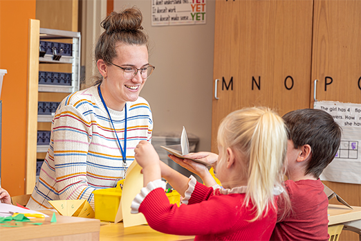 A student teacher works with young children